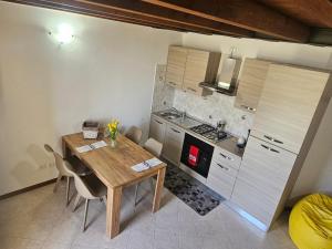 a small kitchen with a wooden table and chairs at MUM & DAD - Loft in Sale Marasino