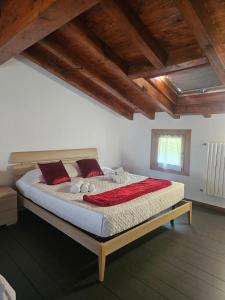 a bedroom with a large bed with red pillows at MUM & DAD - Loft in Sale Marasino