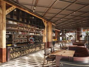 un restaurante con barra con mesas y sillas en Swissôtel Corniche Park Towers Doha, en Doha