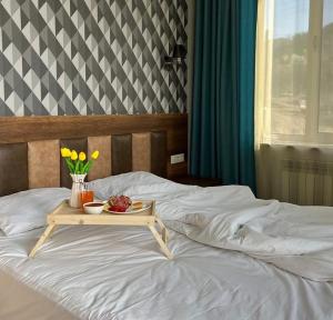 a tray of food and flowers on a bed at Prime LIDER COMPLEX Hotel in VAYK Town in Vaykʼ