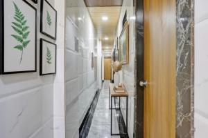 a hallway with white walls and a hallway with a table at Via Chembur Residency in Mumbai