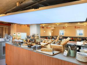 a bakery with a counter with lots of bread at Greet Hotel Nice Aéroport Promenade des Anglais in Nice
