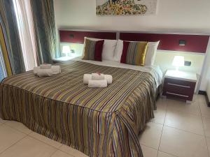 a bedroom with a large bed with towels on it at B&B Vescovo Rosso in Cosenza