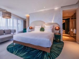 Un dormitorio con una cama grande y una sala de estar en Gem Forest Hotel Nairobi - MGallery Collection, en Nairobi