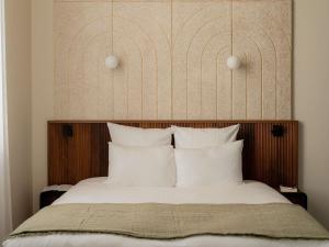 a bedroom with a large bed with white pillows at Hôtel Fort St Laurent Lyon - Handwritten Collection in Lyon
