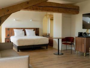 a bedroom with a bed and a table and a couch at Hôtel Fort St Laurent Lyon - Handwritten Collection in Lyon +69 photos