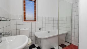 a white bathroom with a toilet and a sink at Blossom Boutique Guesthouse in Muizenberg +13 photos
