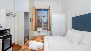 a bedroom with a large white bed and a window at Blossom Boutique Guesthouse in Muizenberg