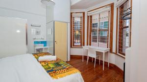 a bedroom with a bed and a table and chairs at Blossom Boutique Guesthouse in Muizenberg