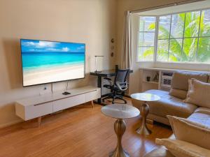 ein Wohnzimmer mit Couch und Flachbildfernseher in der Unterkunft Hawaii Oasis 2-Bedroom at The Cove Waikiki condo in Honolulu