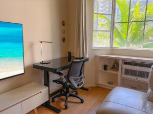 ein Büro mit einem Schreibtisch, einem Stuhl und einem Fenster in der Unterkunft Hawaii Oasis 2-Bedroom at The Cove Waikiki condo in Honolulu