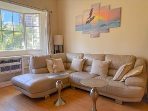 ein Wohnzimmer mit Sofa und Tisch in der Unterkunft Hawaii Oasis 2-Bedroom at The Cove Waikiki condo in Honolulu + 35 Fotos