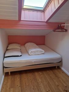 un lit dans une petite pièce avec une fenêtre dans l'établissement Le montagnard, au Monêtier-les-Bains