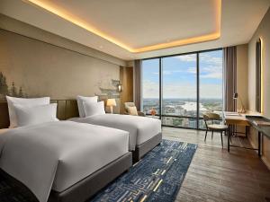 a hotel room with two beds and a desk at Pullman Hai Phong Grand Hotel in Hai Phong +101 photos
