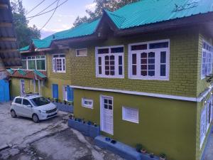 Un coche pequeño aparcado delante de una casa en Sheikh guest house, en Tangmarg