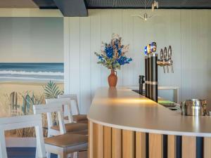 a bar with white chairs and a vase of flowers at ibis Styles Biarritz Plage in Biarritz