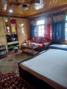 una sala de estar con una cama y un sofá en Sheikh guest house, en Tangmarg