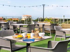 a table with plates of food on top of a roof at ibis Styles Biarritz Plage in Biarritz +117 photos
