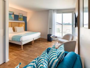 una habitación de hotel con una cama y un sofá en ibis Styles Biarritz Plage, en Biarritz 112 fotos más