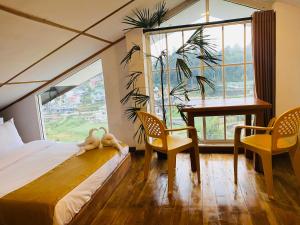 une chambre avec un lit, un bureau et une fenêtre dans l'établissement Infinity Winter Resort, à Nuwara Eliya