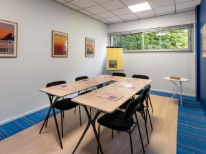 una sala de conferencias con 4 mesas y sillas en ibis Styles Biarritz Plage, en Biarritz