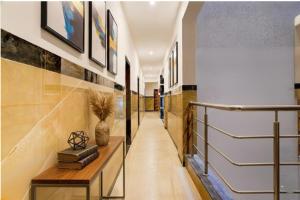 班加罗尔FabHotel Jeevith Garden Residency - Kundalahalli, Brookefield的走廊里有一张桌子，墙上挂着书。