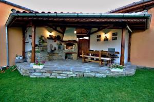 un patio con banco de madera y chimenea de piedra en Private 4BR-2BA guest House Dryanovo with Pool and FREE Parking, en Dryanovo