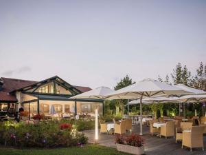 Un patio con mesas, sillas y sombrillas. en Hotel Donibane Saint-Jean-de-Luz, en San Juan de Luz