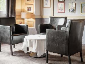 una sala de espera con tres sillas y una mesa en Hotel Donibane Saint-Jean-de-Luz, en San Juan de Luz 169 fotos más