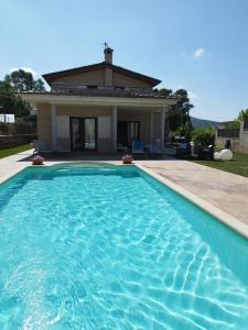 a swimming pool in front of a house at Villa Alba cerca de Sitges in Canyelles