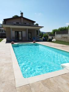 a swimming pool in front of a house at Villa Alba cerca de Sitges in Canyelles