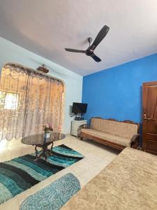 a living room with a couch and a ceiling fan at Casa de Aaron in Colva