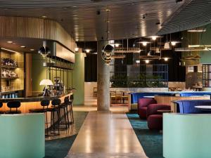 ein Restaurant mit Bar sowie Tischen und Stühlen in der Unterkunft Novotel Melbourne Airport in Melbourne