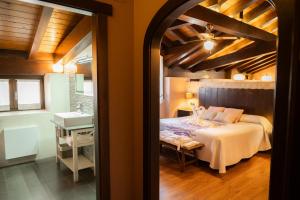 ein Schlafzimmer mit Bett und ein Badezimmer mit Waschbecken in der Unterkunft Casa Rural Aldekoa in Ziga