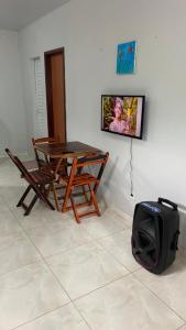a table and chairs and a television in a room at Casa Azul, à 50m da Praia, Ilha dos Frades - Ponta de Nossa Senhora in Salvador