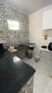 a kitchen with a black counter top in a room at Casa Azul, à 50m da Praia, Ilha dos Frades - Ponta de Nossa Senhora in Salvador