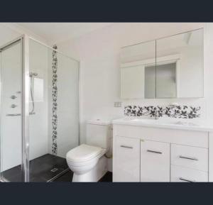 een witte badkamer met een toilet en een wastafel bij Perfect home Nice location quiet holiday home with beautiful yard in Perth
