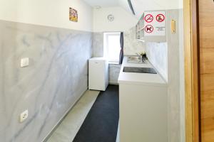 une petite cuisine avec un évier et un comptoir dans l'établissement Flegarrooms, à Cerklje na Gorenjskem