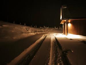 een met sneeuw bedekte weg naast een huis 's nachts bij Na Gorczańskim Wierchu, sauna i balia na wyłączność in Rabka +45 foto's