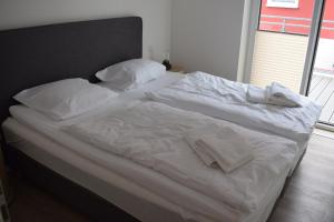 a bed with white sheets and pillows on it at Apart Seegras in Büsum