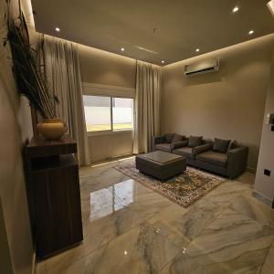 un ampio soggiorno con un divano e un tavolo di استراحة الزهراء a Gedda