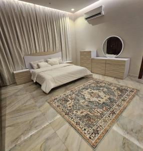 una camera da letto con un letto con un tappeto e uno specchio di استراحة الزهراء a Gedda