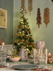 une table de Noël avec un sapin de Noël en arrière-plan dans l'établissement Aurora sauna hideaway lodge, à Tervola