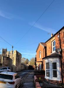 une voiture garée dans une rue à côté de certains bâtiments dans l'établissement Cathedral Quarter House with free Secure Driveway Parking for 2 Cars, à Lincoln