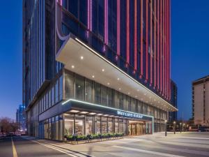 una vista notturna di un edificio con un negozio di Mercure Hefei South Railway Station a Hefei