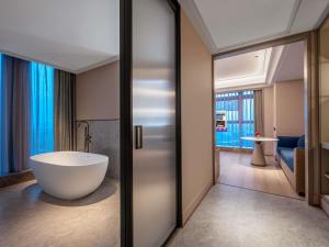 bagno con vasca e grande specchio di Mercure Hefei South Railway Station a Hefei Altre 43 foto