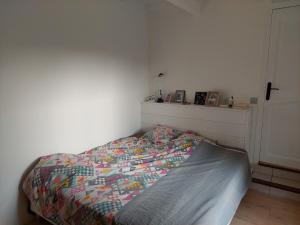 佩罗勒Villa entre Montpellier et Camargue的卧室里有一张床，床上铺着色彩鲜艳的被子