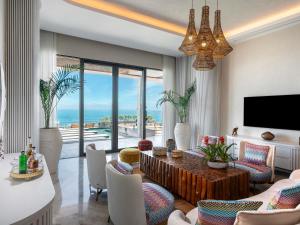 ein Wohnzimmer mit Tisch und Stühlen und einem Fernseher in der Unterkunft Swissôtel Living Bodrum in Bodrum City