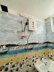 baño con un mural de playa en la pared en Uvindu Villa - Cozy By Midigama, en Weligama