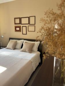 Casa Roberta - Esperienze di campagna في ريجيو إيميليا: سرير مع ملاءات ووسائد بيضاء في غرفة النوم